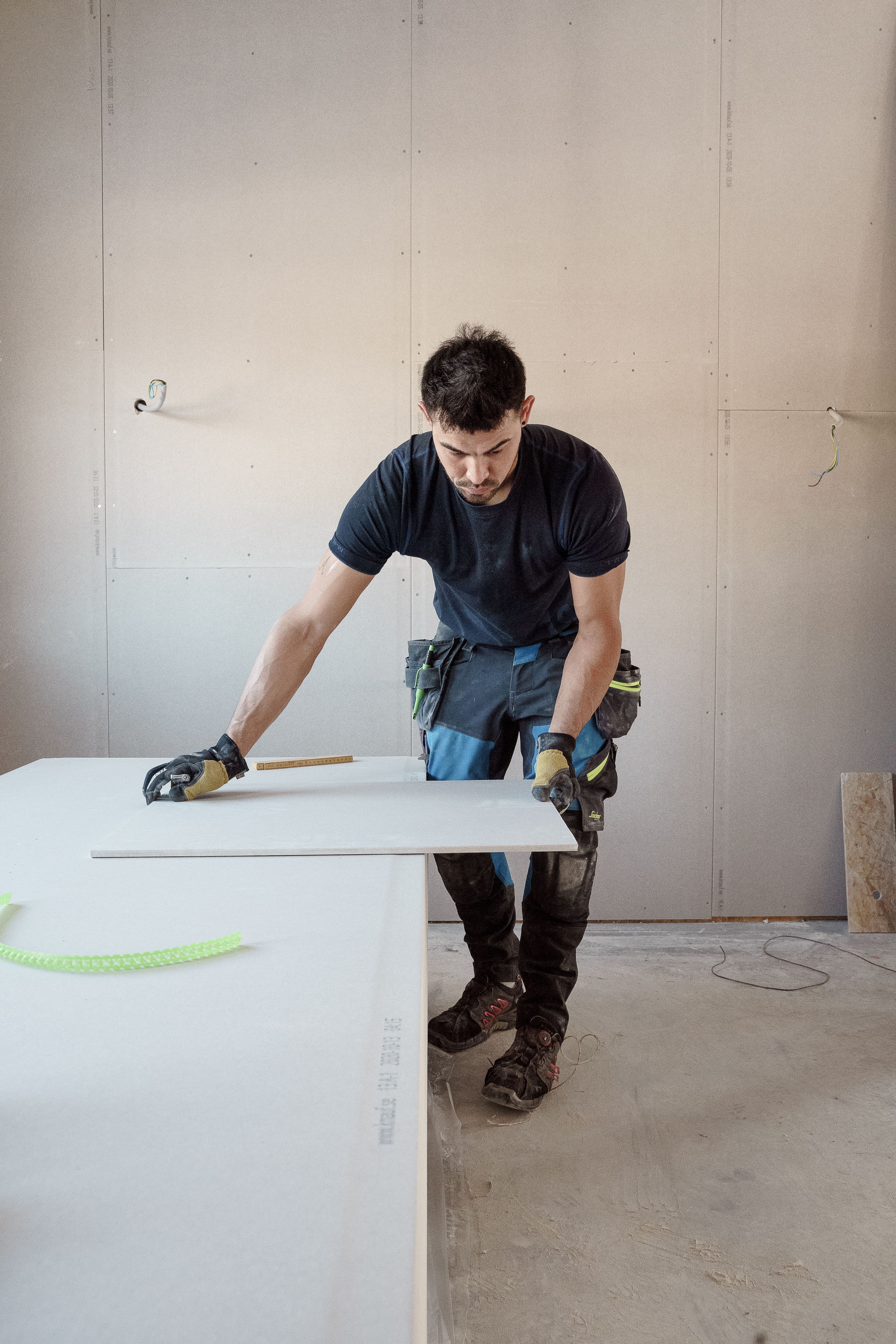 Vakman werkt met gereedschap tijdens het monteren van gipsplaten.