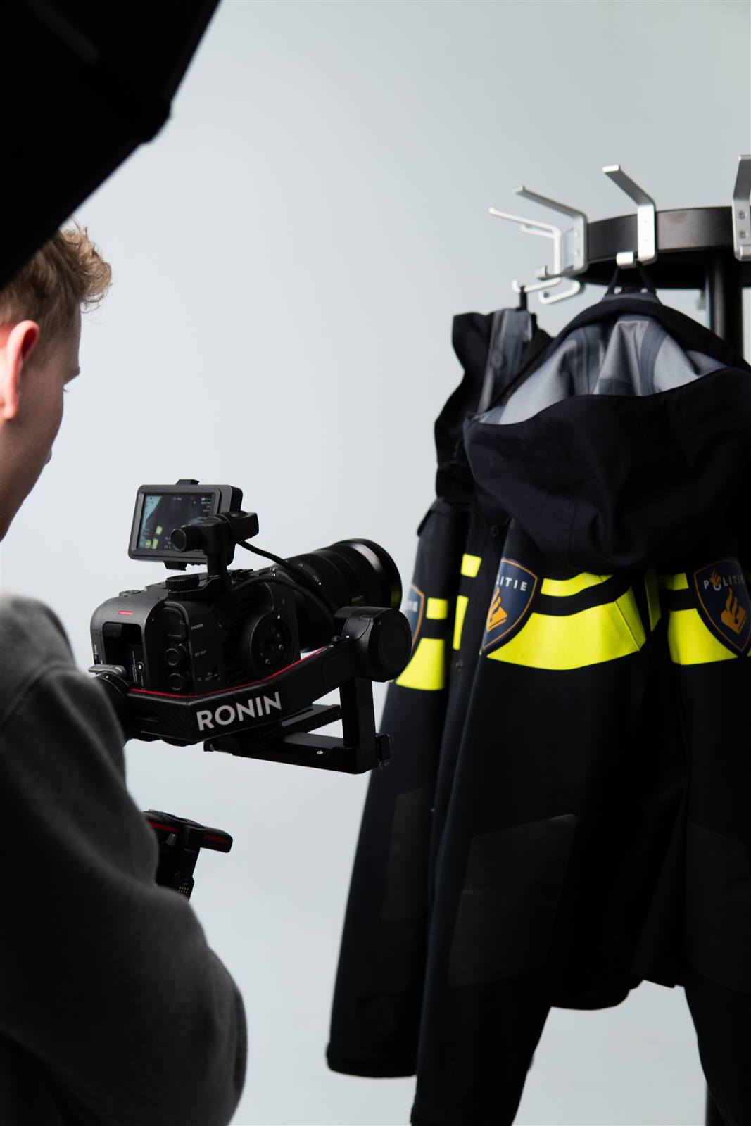 Cameraman filmt politie-uniformen met een gimbal in de studio.